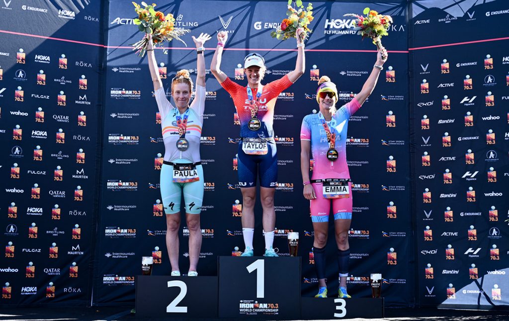 Women standing on the podium raising their arums while holding bouquets