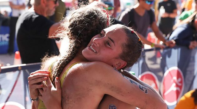 Two triathletes embrace after finishing the race