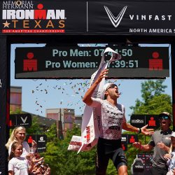 Rudy von Berg celebrates victory while breaking the tape at the 2023 IRONMAN Texas